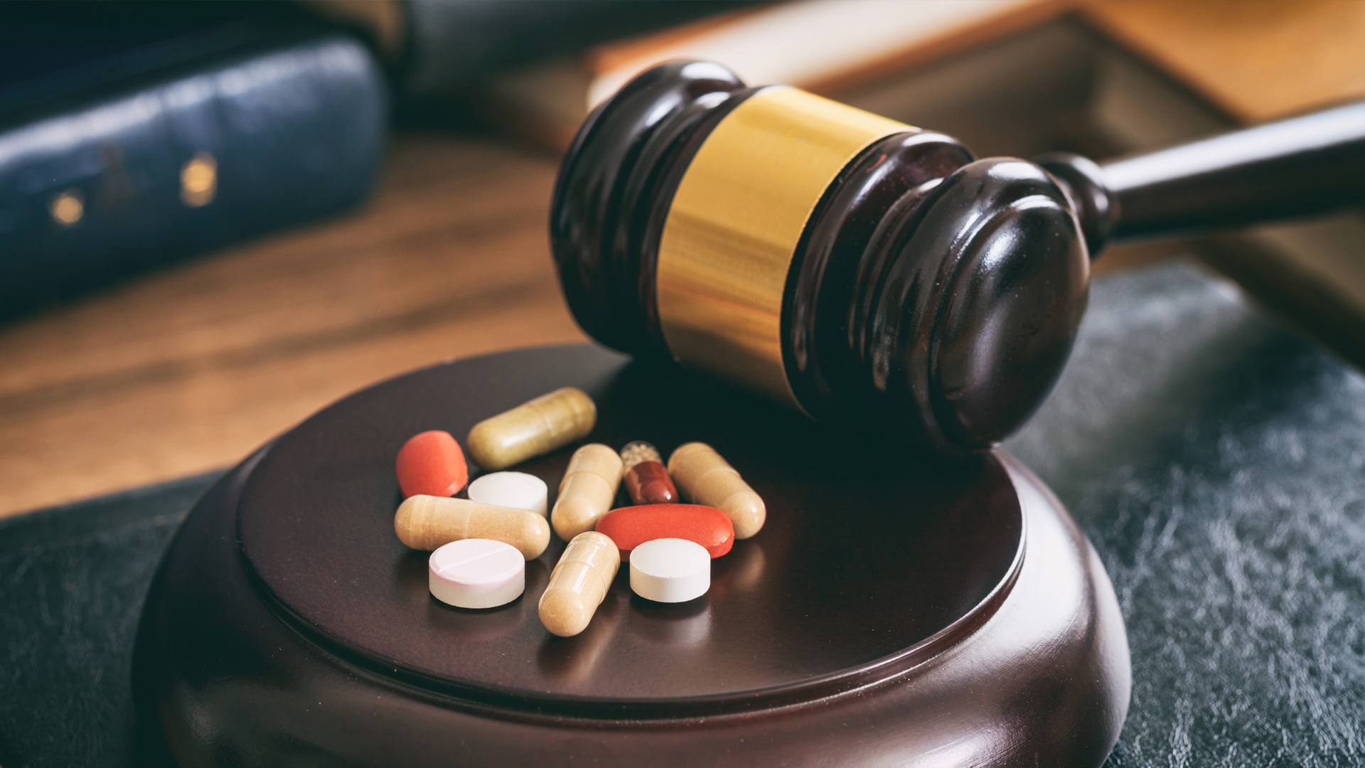 Drug pills next to a gavel